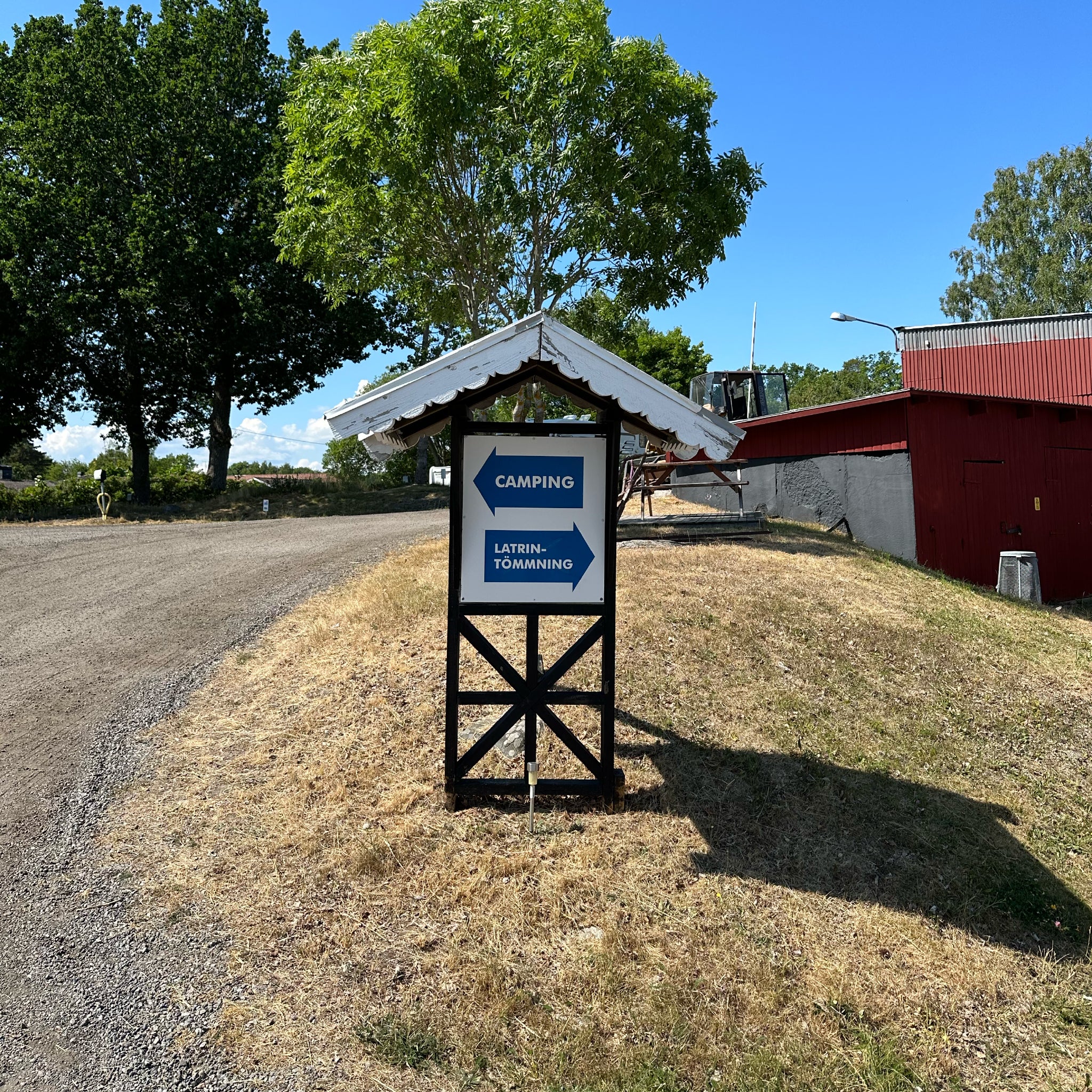 Skylt för camping och latrintömning på somrig campingplats